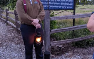 Man Holding Lantern Next To Trail Of Hope